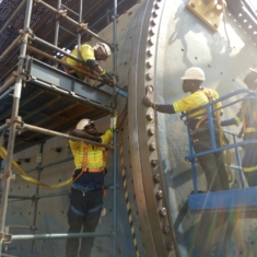 FIXING BOLTS INTO A SECTION OF THE MILL DISCHARGE HEAD.